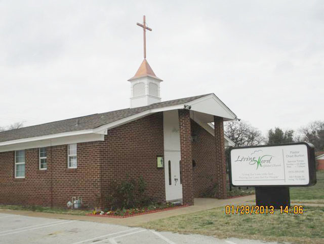 cupola with large cross weathervane on brick church