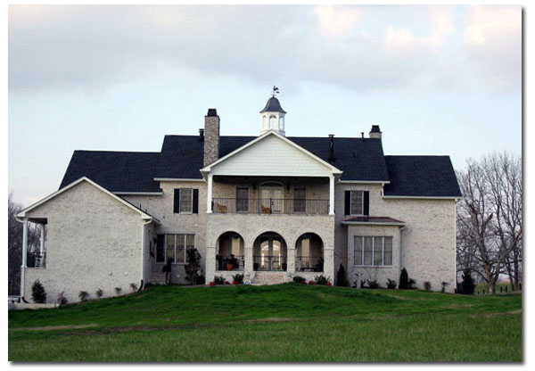 paddock cupola with windows and rooster on a large brick house back view