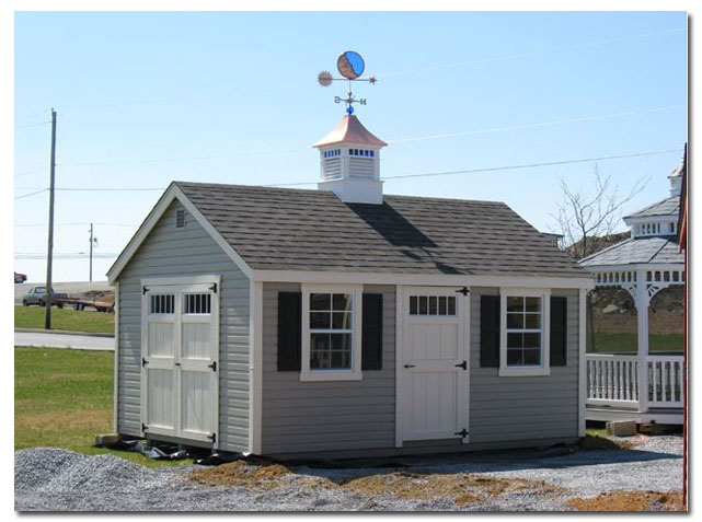 blue stained glass cupola with moon weathervane on a shed